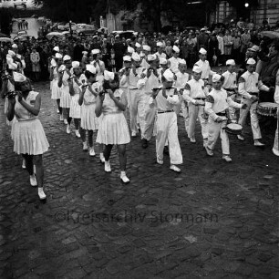 Karpfenfest: Umzug: Spielmannszug: dahinter Zuschauer, mit Regenschirmen: im Hintergrund geparkte Autos, 8. Oktober 1961