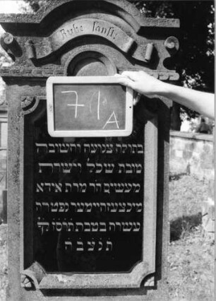 Grabstein 71 (Index: 99801947) Material: Sandstein mit schwarzer Marmorplatte Zustand: gut Maße HxBxT: 180x55x26 cm Beschreibung: Stele, getreppter Sockel, eingezogener Rundbogenabschluß mit Verdachung, gerahmte Schrifttafel rechteckig Symbolik: Schriftband, seitlicheVoluten: Grabstein 71A