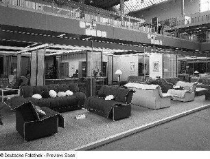 Leipziger Herbstmesse, 1984. Raumaufnahme mit Ausstellungskojen des VEB Thüringer Möbelkombinat Suhl. Ansicht mit Sitzgruppen