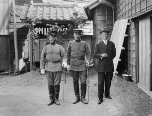 Nagasaki?. Gruppenbildnis eines Touristen mit zwei Einheimischen in Uniform