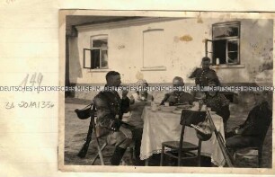 Angehörige der Ordnungspolizei und zwei Frauen bei einer Vesper vor einem Wohnhaus
