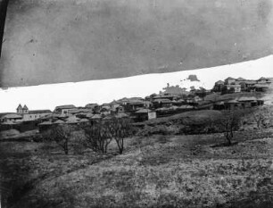 Siedlung : Blick über ein Feld auf eine Siedlung.