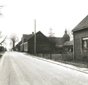 Calau-Saßleben-Kalkwitz, Hauptstraße 9. Ehemaliges Gasthaus "Hermann Heinrich" (1905). Straßenansicht mit Dorfkirche