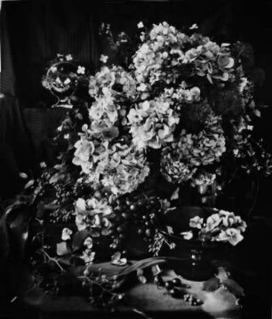 Stilleben. Tischarrangement mit Blumen und Weintrauben