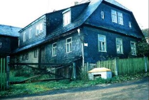 eingeschossiges, geschiefertes Haus mit Walmdach und Satteldachgaupen