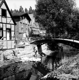 Trave: Stadtarm: mittig Kinder am Ufer, rechts Brücke zwischen der Hude und Heiligengeiststraße, links Gebäude der Heiligengeiststraße, Blick nach Norden