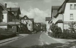 Blick durch eine Straße mit Wohn- und Geschäftshäusern zum Riesengebirgskamm