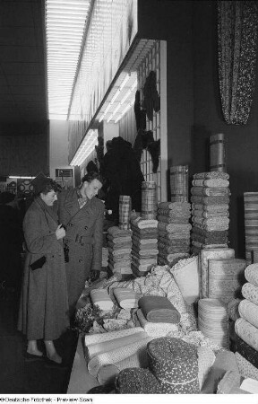 Besucher vor einem Messestand mit Stoffen in der Messehalle des Ausstellungslandes Bulgarien