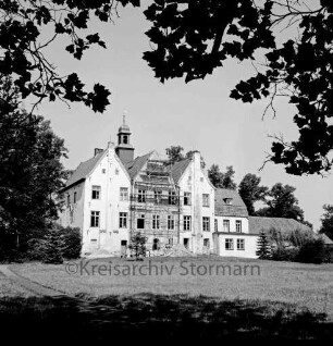 Kloster Nütschau: Herrenhaus: Restaurierung der Südfront: Gerüst vor Mittelflügel: davor Baumaterial: vorn Rasenfläche: rechts und links Bäume