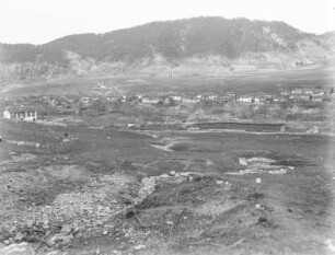 Siedlung : Blick über die Gebäude einer Siedlung mit angrenzender Gebirgslandschaft.