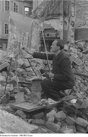 Theodor Rosenhauer arbeitet zwischen Trümmern an seinem Ölgemälde "Blick auf das Japanische Palais nach dem Angriff"