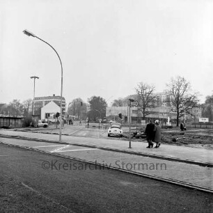 Möllner Landstraße: Ausbau um neues Ortszentrum: in der Mitte abgeschnittene alte Straßenführung: rechts Paar auf Gehweg: hinten links Rathaus und Bürgerhaus Glinde [später Marcellin-Verbe-Haus]: hinten rechts Geschäftshäuser