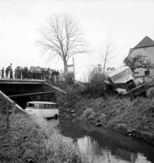 Verkehrsunfall: Kalkgraben / Einmündung in Hamburger Chaussee - B 75 / Brücke über Heilsau: Zementlastwagen mit Anhänger schräg auf Böschung: Wäscherei-Lieferwagen in Heilsau: rechts oben Haus: links oben an Brückengeländer der B 75 Zuschauer, Baum, Wegweiser nach Ahrensbök: rechts oben Haus, Zaun: im Vordergrund links Uferböschung, Zaun