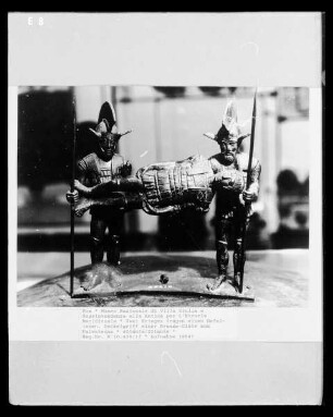 Zwei Krieger tragen einen Gefallenen. Deckelgriff einer Bronze-Ciste aus Palestrina