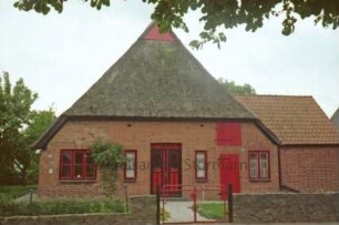 Dorfstraße 32: Backsteinkate mit Reetdach: Teilansicht: giebelständige Straßenfront: mit Eingangstür und Stalltür: rechts Anbau