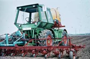 Fotografie: Pflegegerät, Hackmaschine, Frontanbau, Systemtraktor, Feldspritze angebaut, Bandspritzung