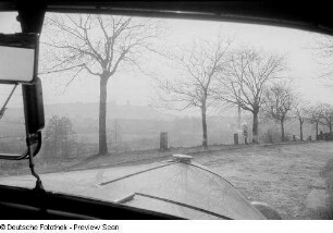 Blick aus der Frontscheibe eines Autos auf eine Straße und in die Landschaft, vermutlich in Thüringen