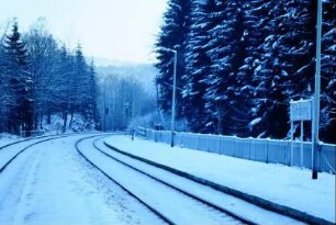 Blick entlang des verschneiten Bahnsteiges und der Gleisanlagen