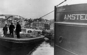 Niederlande. Am Hafen von Amsterdam. Im Vordergrund mehrere Schuten. Im Hintergrund eine Zugbrücke.