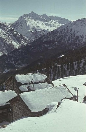 Mittenwald. Blick über schneebedeckte Dächer auf die Alpen