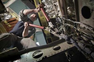 Air Maintenance Services; AMS; Firma; Betrieb; Inspektion; Wartung; spezialisiert auf Flugzeug-Recycling; Airbus; A 300; A300; Airbase Ahlhorn; Ahlhorn; Entsorgung. Ahlhorn, 2006, hier: unterhalb der Pilotensitze werden Kabelbäum zur Entsorgung heraus geschnitten
