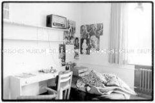 Zimmer mit Bett, Regal und Schreibtisch, an der Wand Poster (Altersgruppe 14-17)