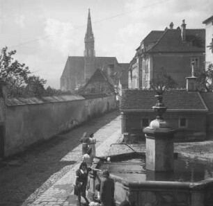 Frauen am Brunnen : Einige Frauen an einem Brunnen. Im Hintergrund der Kirchturm der Stadtpfarrkirche Steyr.