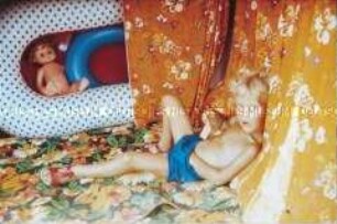 Kleiner Junge mit kurzer blauer Hose in einer Art Zelt (Altersgruppe 14-17)