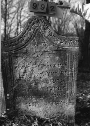 Grabstein 992 (Index: 99751354) Material: Sandstein Zustand: abgeblätt/verwitt/großer Textverlust Maße HxBxT: 122x81x14 cm Beschreibung: Stele, Eselsrückenabschluß, Schriftfeld eingetieft: Grabstein 992