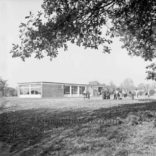 Dörfergemeinschaftsschule: Grund- und Hauptschule: vorn Rasenfläche: hinten rechts Schulkinder: dahinter Klassentrakte: oben Baumäste