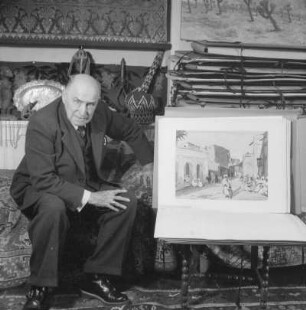 Marburg. Der Maler Prof. Ernst Vollbehr (1876-1960) in seiner Wohnung neben einem Gemälde sitzend