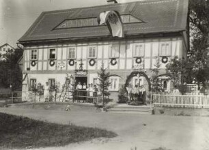 Seifhennersdorf (obersorbisch Wodowe Hendrichecy). Wohnhaus mit Fahne und Schmuck zum Sängerfest. Straßenansicht