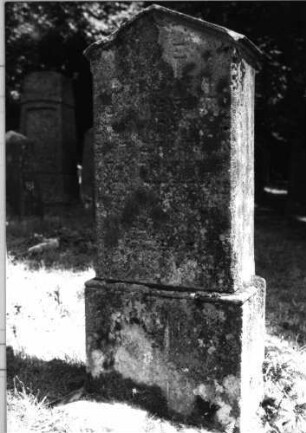 Grabstein 139 (Index: 100085471) Zustand: stark verwittert mit Textverlust Maße HxBxT: 130x50x27 cm Beschreibung: Stele, Sockel, giebelartiger Abschluß mit Verdach.: Grabstein 139
