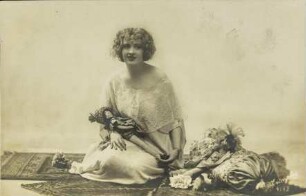 [Frau mit Puppe auf Schoß]