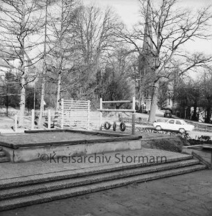 Stadtschule: Königstraße / Kirchberg: vorn Spielplatz mit Holzklettergerüst, Stufen und Sandkasten: dahinter links Pastorat: hinten rechts Pkws und Peter-Paul-Kirche hinter Bäumen: 3. Februar 1973