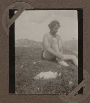 Heinrich Zimmer in Badehose auf einer Wiese sitzend