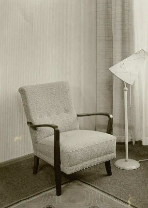 Sessel : Sessel (1956; Sächsische Sitzmöbelwerkstätten Waldheim) neben Stehlampe in Ausstellungskoje