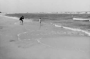Vater fotografiert seine Tochter am Meer