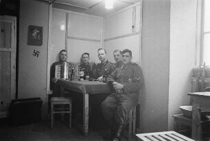 Zweiter Weltkrieg. Niederlande unter deutscher Besatzung. Wehrmachtsangehörige in einer Unterkunft (wohl bei Den Haag). Ansicht mit Akkordeonspieler