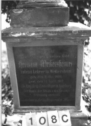 Grabstein 108 (Index: 99609744) Material: Sandstein, Schriftplatte Granit Maße HxBxT: 224x63x40 cm Beschreibung: Block, darauf abgebrochene Säule mit gesenkter (geknickter) Rose, im Block Schriftplatte, Sockel Symbolik: geknickte Rose, abgebrochene Säule: Grabstein 108C