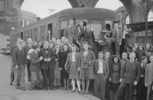 Aufnahmen einer Gruppe junger Leute vor einer Straßenbahn