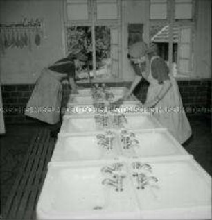 Arbeitsmaiden beim Reinigen des Waschraumes in einem Reichsarbeitsdienstlager in Mecklenburg