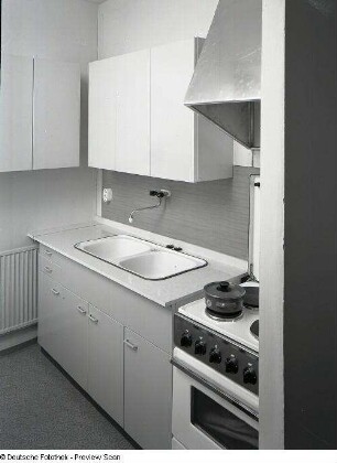 Vierraumwohnung des Typs WBS 70. Küche. Ansicht mit Spüle, Hängeschränken und Elektroherd