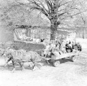 Mitglieder des DFD und Bäuerinen der LPG Mestlin (Kr. Parchim) fahren mit einem Pferdewagen zur Arbeit