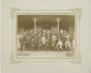 Offizierskorps des Regiments, neununddreissig Offiziere in Uniform mit Mütze (unter ihnen ein Zivilist), stehend oder sitzend, auf dem Truppenübungsplatz Münsingen