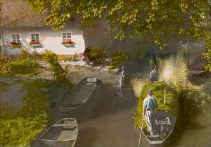 Leipe im Spreewald. Heutransport auf dem Wasserwege. Zwei Stakende im Spreewaldkahn auf einem Fließ vor einem Bauernhaus