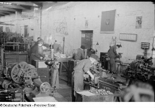 Lehrlinge bei der Arbeit an Werkbänken