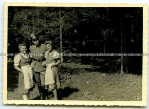 Wehrmachtsoffizier mit zwei Frauen im Wald