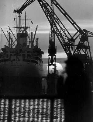 In einer Werft. Die Herbstsonne geht unter. Sie verschwindet hinter dem Trockendock
