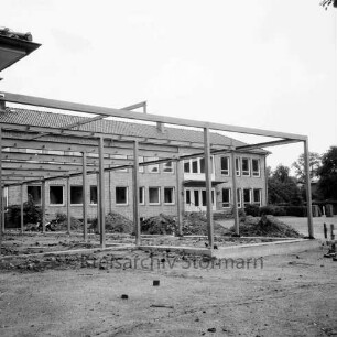 Volksschule [später Emil-Nolde-Schule]: am Schweinemarkt: Erweiterungsbau: Pausenhalle in Bau: Fundamente, Stahlkonstruktion: Erdhaufen: im Hintergrund Klassentrakt